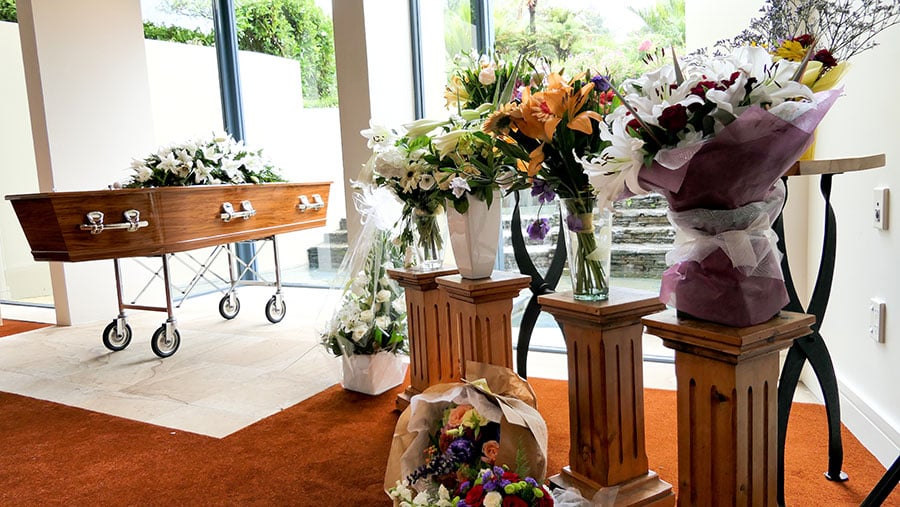 funeral flowers next to a casket