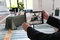A pair of hands holding up a computer tablet at a funeral.